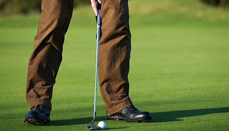 Close up of a golfball on the fairway with the green just ahead