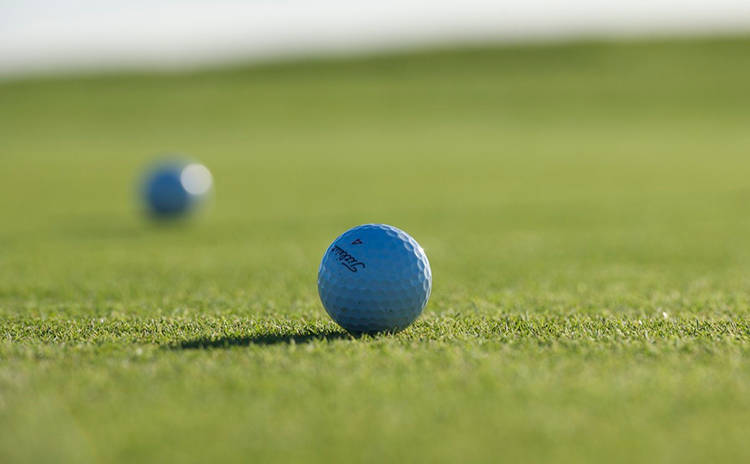Two golf balls sitting on golf course green